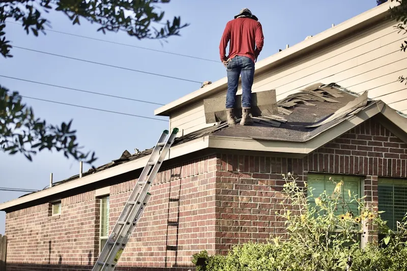 Professional roofer working on a residential roof in West Woods
